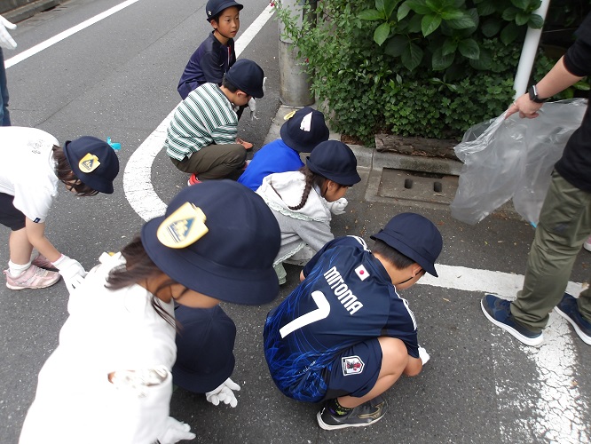 ゴミを発見し、みんなで拾っています。